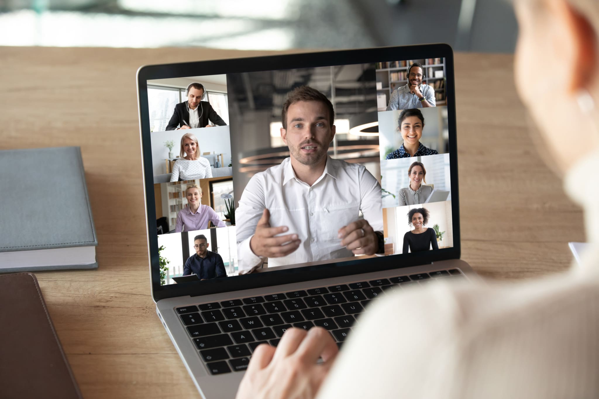 A group of coworkers shown on a laptop screen, working from home.